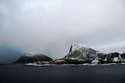 Scenic view of sea and mountains against sky