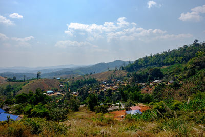 Scenic view of trees and houses against sky