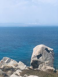 Scenic view of rocks in sea against sky