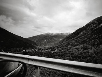 Road by mountains against sky