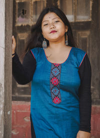 Portrait of woman standing against building