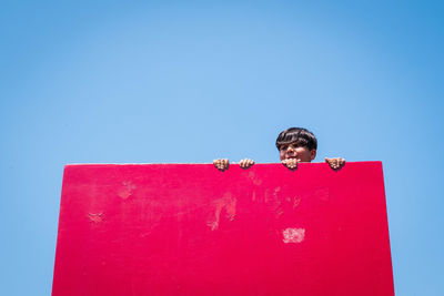 Low angle view of man against blue sky