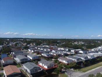 High angle view of houses and cityscape against clear blue sky