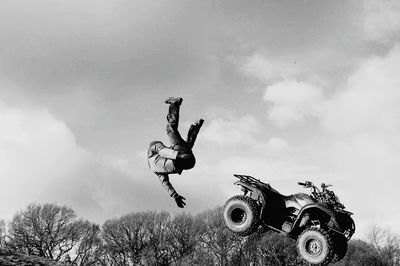 Man jumping on field against sky