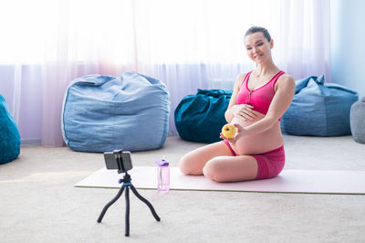 Smiling young woman sitting on bed