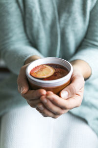 Midsection of man holding coffee cup