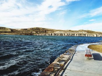 Scenic view of river against cloudy sky