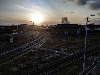 Train at railroad station against sky during sunset