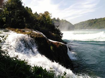 Scenic view of waterfall against sky