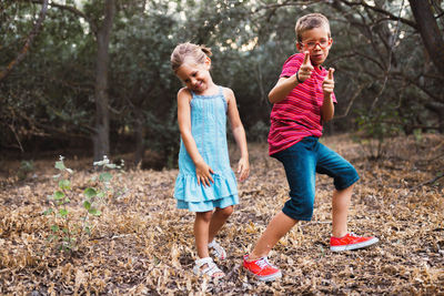 Full length of boy ad girl playing while dancing on land