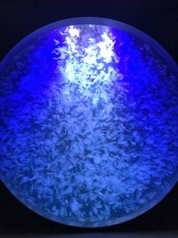 Close-up of illuminated glass against blue background