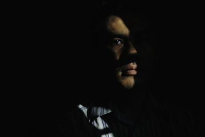 Portrait of man against black background