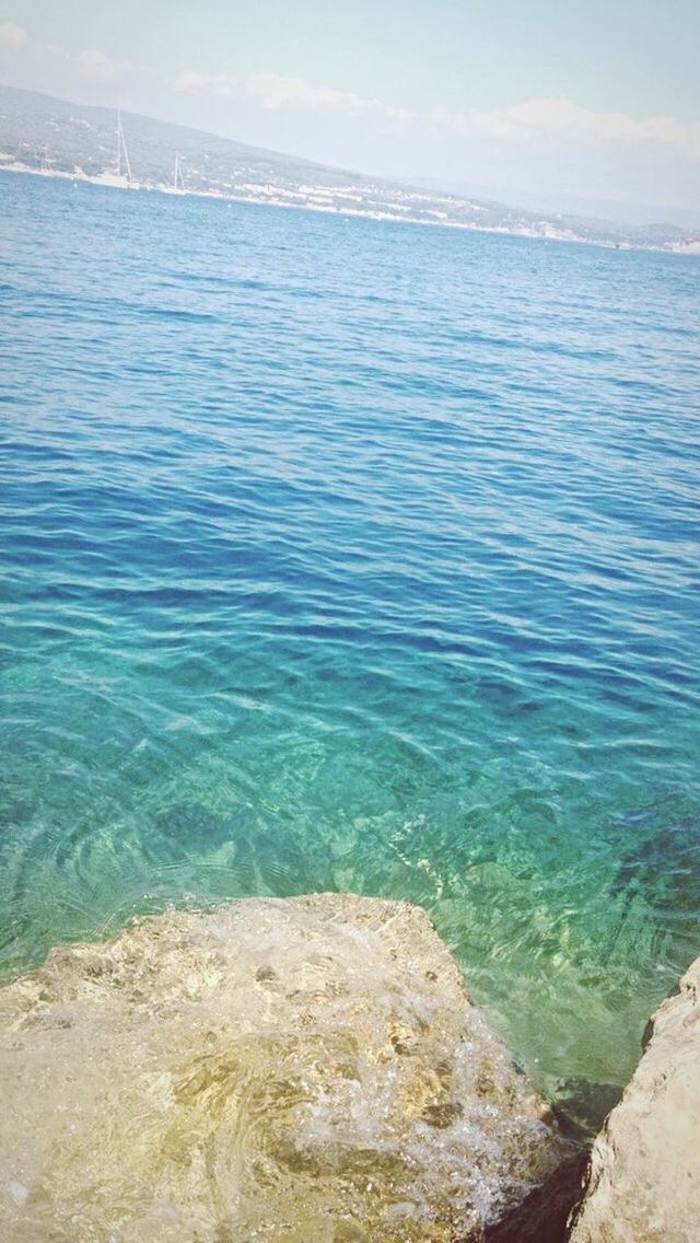 water, sea, tranquil scene, tranquility, scenics, beauty in nature, blue, nature, rippled, rock - object, sky, idyllic, high angle view, day, remote, outdoors, no people, non-urban scene, calm, rock