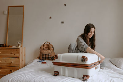 Woman with the baggage at home, preparing to flight