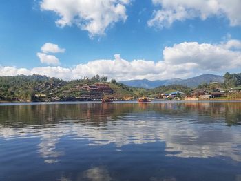 Scenic view of lake by city against sky