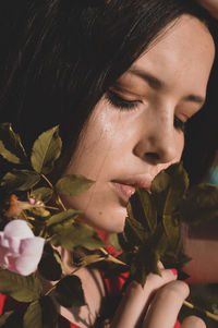 Close-up portrait of woman with red eyes closed