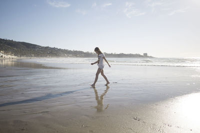 Full length of man standing on beach against sky