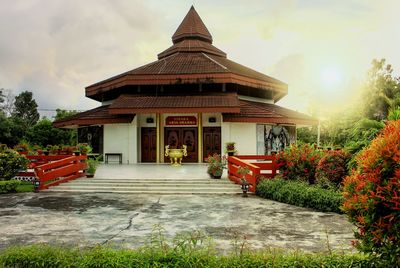 View of red building and trees against sky