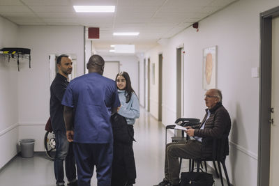 Rear view of male pediatrician talking to female patient at healthcare center