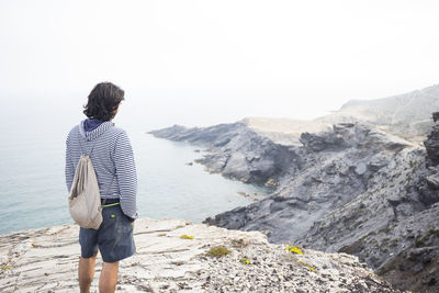 Spain, murcia, young man looking at the sea