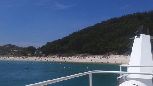 Swimming pool by sea against clear blue sky