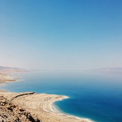 Scenic view of beach against clear blue sky