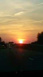 Cars on road at sunset