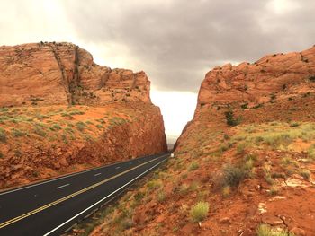 Empty narrow road along rocky landscape