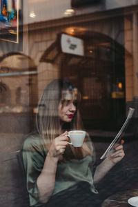 Young woman drinking coffee at cafe