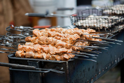 Close-up of meat in skewers on barbecue grill