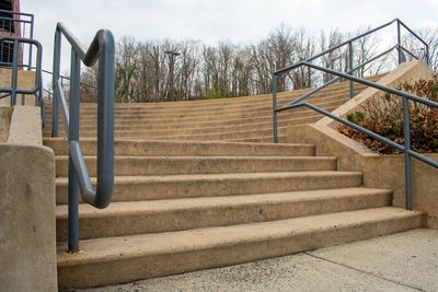 A set of small concrete steps with a green railing in a shopping center in suburban pennsylvania