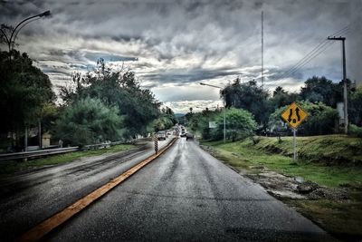 Country road against cloudy sky