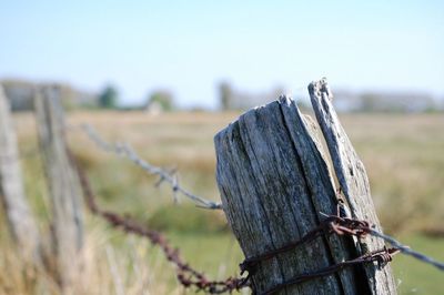 Close-up of wooden post against sky