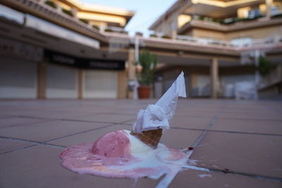 Close-up of ice cream cone against buildings in city