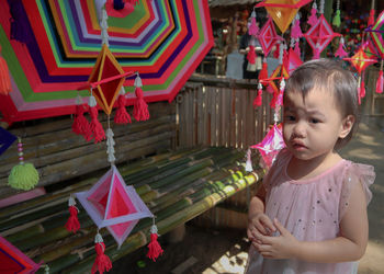 Cute girl looking away while standing at market