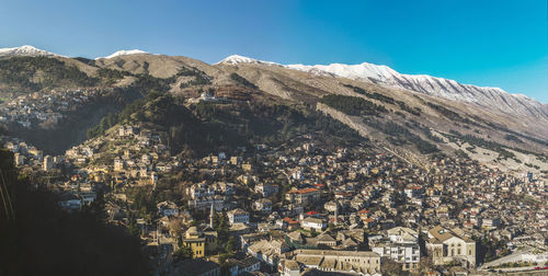 High angle view of houses and mountains against clear blue sky