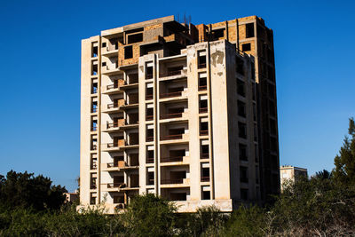 Low angle view of modern building against clear blue sky