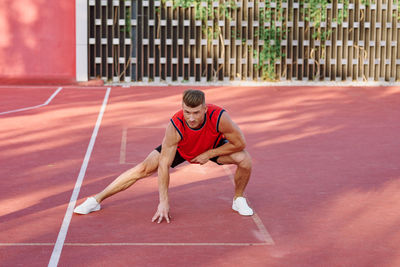 Full length of woman exercising on field