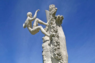 Low angle view of statue against blue sky