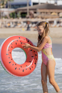The girl enters the water with an inflatable ring. rest on the sea.