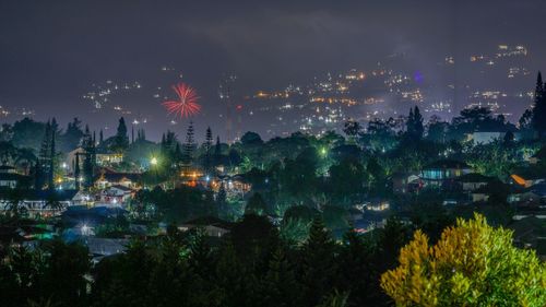 Panoramic shot of illuminated cityscape against sky at night