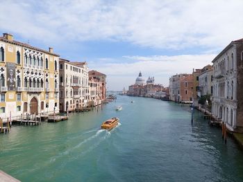 Buildings by river against sky