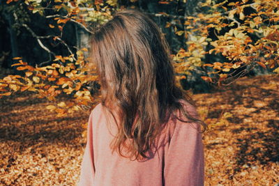 Rear view of woman with autumn leaves