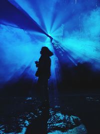 Rear view of silhouette woman standing at music concert