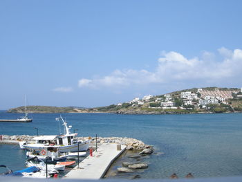 Scenic view of sea by cityscape against sky