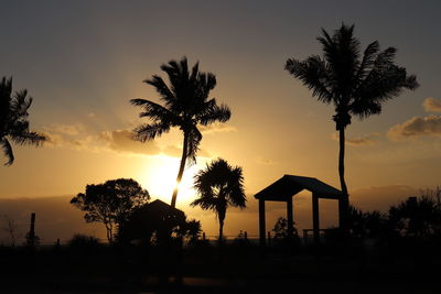 Silhouette palm trees against sky during sunset