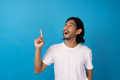 Portrait of a smiling young man against blue background