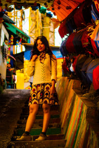 Full length of woman standing against multi colored wall