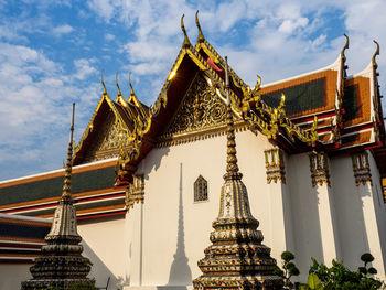 A section of the wat pho temple, with intricate golden roof details reflecting the sun's rays.