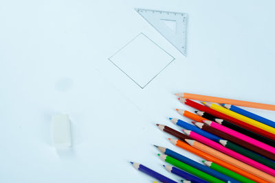 High angle view of colored pencils on white background